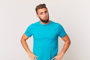 Kafası karışmış ve kafası karışmış genç yakışıklı bir adam. fitness konsepti