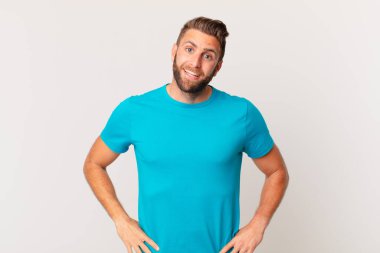 Genç yakışıklı adam mutlu ve hoş bir şekilde şaşırmış görünüyor. fitness konsepti