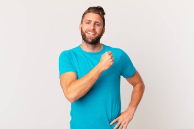 Genç yakışıklı adam kendini mutlu hissediyor ve bir meydan okumayla yüzleşiyor ya da kutluyor. fitness konsepti