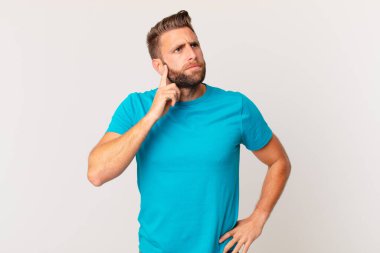 Genç yakışıklı düşünen, kuşkulu ve kafası karışık bir adam. fitness konsepti