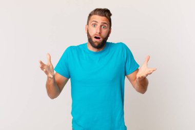 Genç ve yakışıklı bir adam şok olmuş ve şaşırmış hissediyor. fitness konsepti