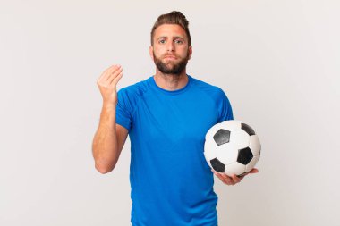 Genç yakışıklı adam kapiş ya da para hareketi yapıyor, sana ödemeni söylüyor. futbol kavramı