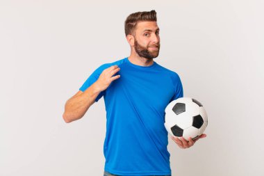 Genç yakışıklı adam kibirli, başarılı, pozitif ve gururlu görünüyor. futbol kavramı