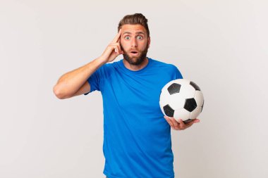 Genç yakışıklı adam şaşırmış görünüyor, yeni bir düşünce, fikir ya da konsept fark ediyor. futbol kavramı