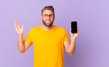 young handsome man feeling happy and astonished at something unbelievable. cell concept