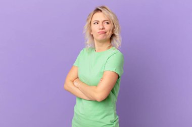 Genç, güzel bir kadın omuz silkiyor, kafası karışık ve kararsız.