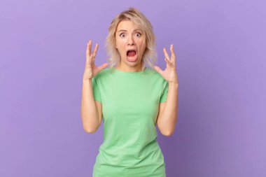 Genç ve güzel bir kadın ellerini havaya kaldırarak çığlık atıyor.