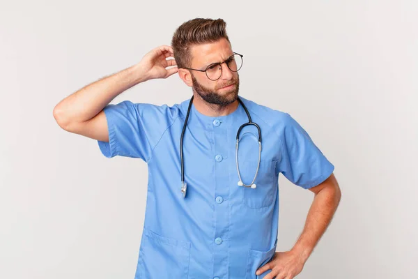 Young Handsome Man Feeling Puzzled Confused Scratching Head Nurse Concept — Stok fotoğraf