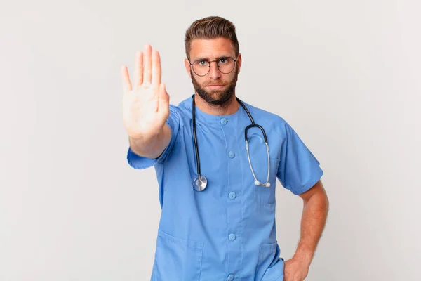 ヤングハンサムな男が真剣に手の平を開いてジェスチャーを止める 看護師の概念 — ストック写真