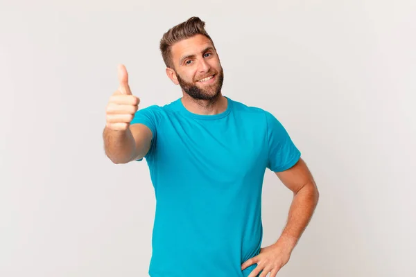 Joven Hombre Guapo Sentirse Orgulloso Sonriendo Positivamente Con Los Pulgares — Foto de Stock