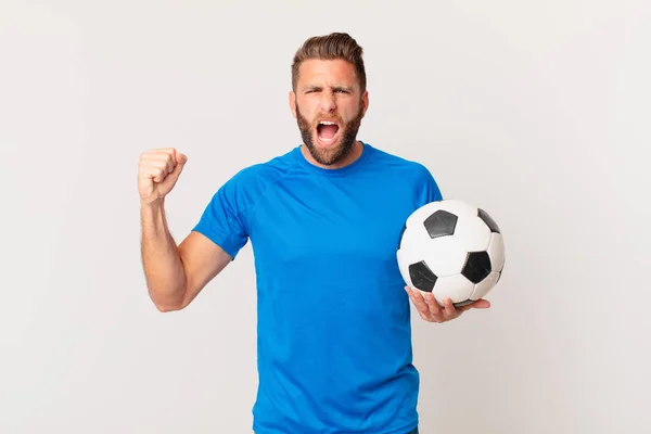 怒りの表情で積極的に叫んでいる若いハンサムな男 サッカーのコンセプト — ストック写真