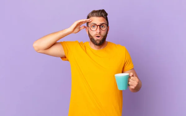 Young Handsome Man Looking Happy Astonished Surprised Holding Coffee Mug — Φωτογραφία Αρχείου