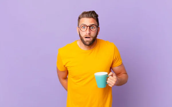 Young Handsome Man Looking Very Shocked Surprised Holding Coffee Mug — Φωτογραφία Αρχείου