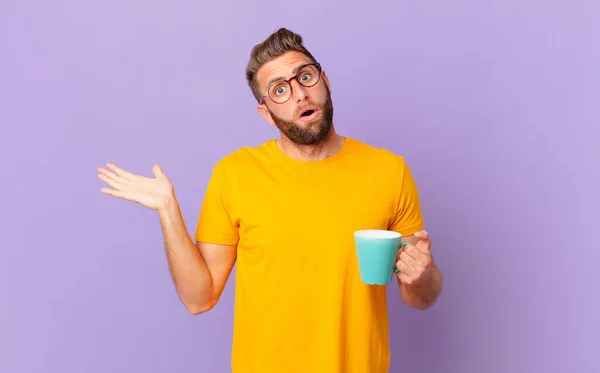 Young Handsome Man Looking Surprised Shocked Jaw Dropped Holding Object — Φωτογραφία Αρχείου