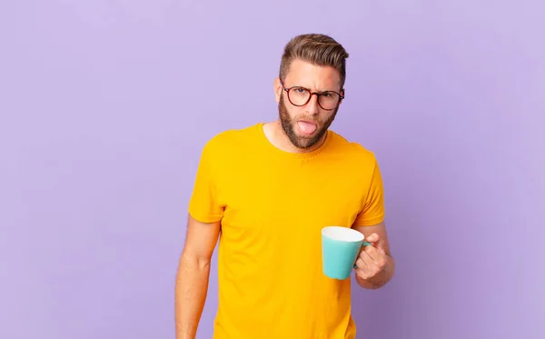 Young Handsome Man Feeling Disgusted Irritated Tongue Out Holding Coffee — Φωτογραφία Αρχείου