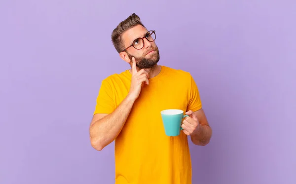 Young Handsome Man Thinking Feeling Doubtful Confused Holding Coffee Mug — Φωτογραφία Αρχείου