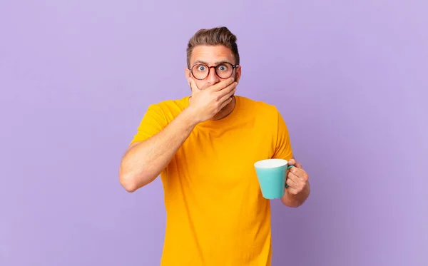 Young Handsome Man Covering Mouth Hands Shocked Holding Coffee Mug — Stockfoto