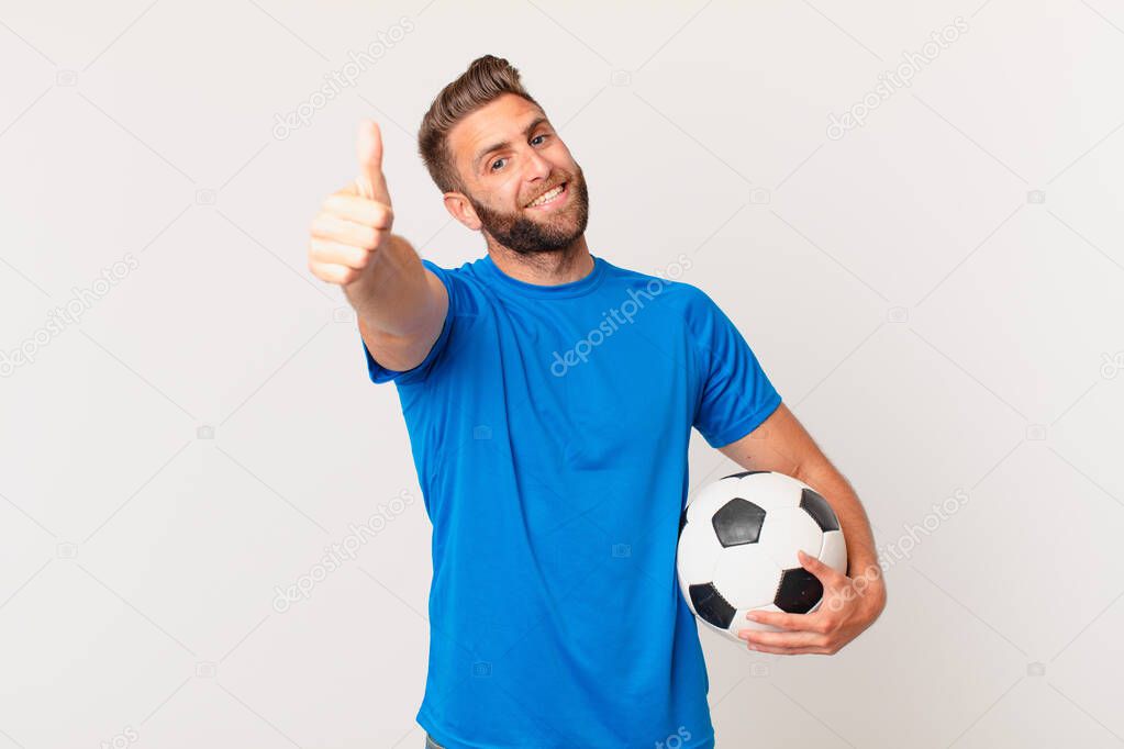 young handsome man feeling proud,smiling positively with thumbs up. soccer concept