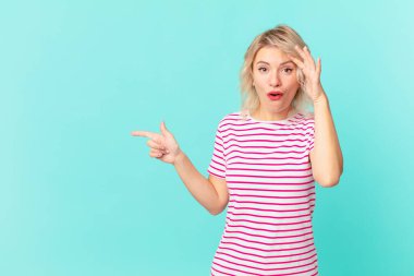 young pretty woman looking happy, astonished and surprised. copy space concept