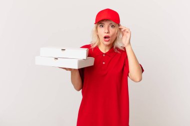 young pretty woman looking surprised, realizing a new thought, idea or concept. pizza delivering concept