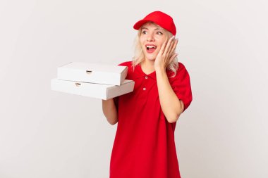 young pretty woman feeling happy, excited and surprised. pizza delivering concept