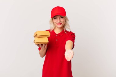 young pretty woman smiling happily with friendly and  offering and showing a concept. burger delivering concept