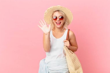 young pretty woman smiling and looking friendly, showing number five. summer tourist concept