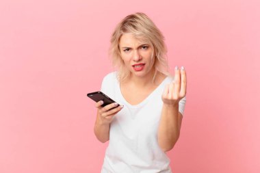 young pretty woman making capice or money gesture, telling you to pay. cell concept