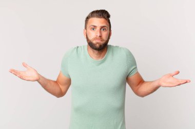 Genç yakışıklı adam şaşkın, şaşkın ve şüpheci hissediyor.