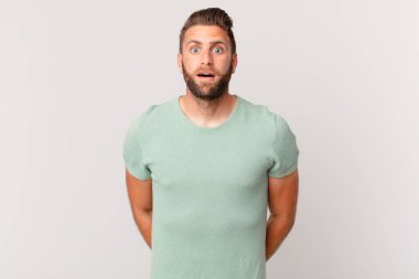 Genç yakışıklı adam çok şaşırmış ya da şaşırmış görünüyor.
