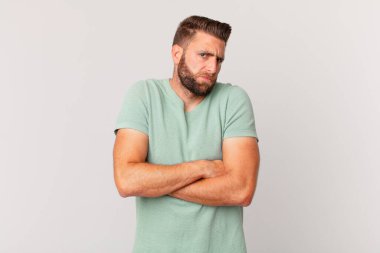 Genç yakışıklı adam omuz silkiyor, kafası karışık ve kararsız.