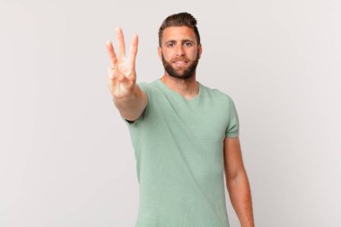 Genç yakışıklı adam gülümsüyor ve arkadaş canlısı görünüyor.