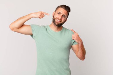 Genç ve yakışıklı bir adam, kendine güvenerek gülümsüyor.