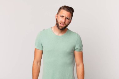 Genç yakışıklı adam şaşkın ve şaşkın hissediyor.