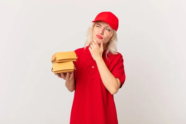 Young Pretty Woman Thinking Feeling Doubtful Confused Burger Delivering Concept — Stockfoto