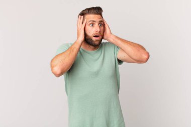 Genç yakışıklı adam mutlu, heyecanlı ve şaşırmış hissediyor.