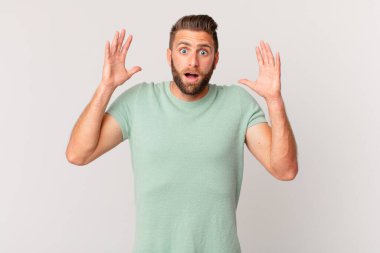 Genç yakışıklı adam ellerini havaya kaldırarak bağırıyor.