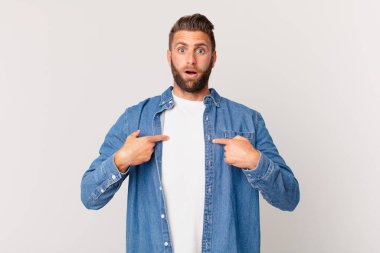 Genç yakışıklı adam mutlu hissediyor ve heyecanla kendini işaret ediyor.