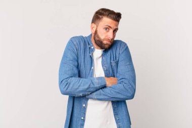Genç yakışıklı adam omuz silkiyor, kafası karışık ve kararsız.