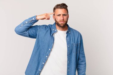 Genç yakışıklı adam kafası karışık ve şaşkın hissediyor, deli olduğunu gösteriyor.