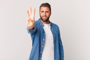 Genç yakışıklı adam gülümsüyor ve arkadaş canlısı görünüyor.