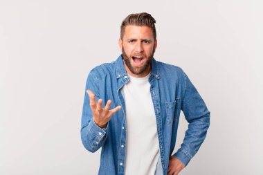 Genç yakışıklı adam sinirli, sinirli ve sinirli görünüyor.