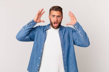 Genç yakışıklı adam ellerini havaya kaldırarak bağırıyor.