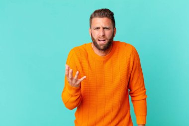 Genç yakışıklı adam sinirli, sinirli ve sinirli görünüyor.