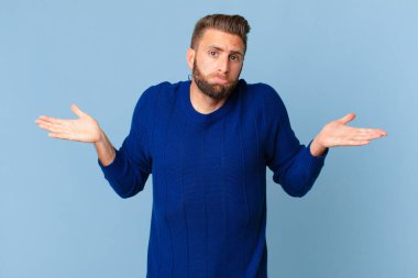 Genç yakışıklı adam şaşkın, şaşkın ve şüpheci hissediyor.