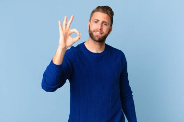 Genç yakışıklı adam kendini mutlu hissediyor, onayını veriyor.