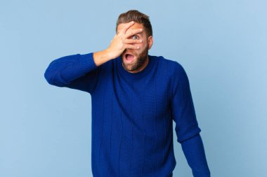 Genç yakışıklı adam şok olmuş, korkmuş ya da korkmuş görünüyor.