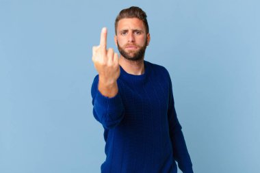 Genç ve yakışıklı adam sinirli, sinirli, asi ve agresif hissediyor.