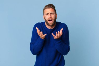 Genç yakışıklı adam umutsuz, hayal kırıklığına uğramış ve stresli görünüyor.