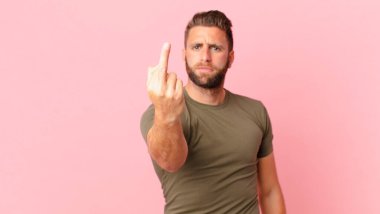 Genç ve yakışıklı adam sinirli, sinirli, asi ve agresif hissediyor.